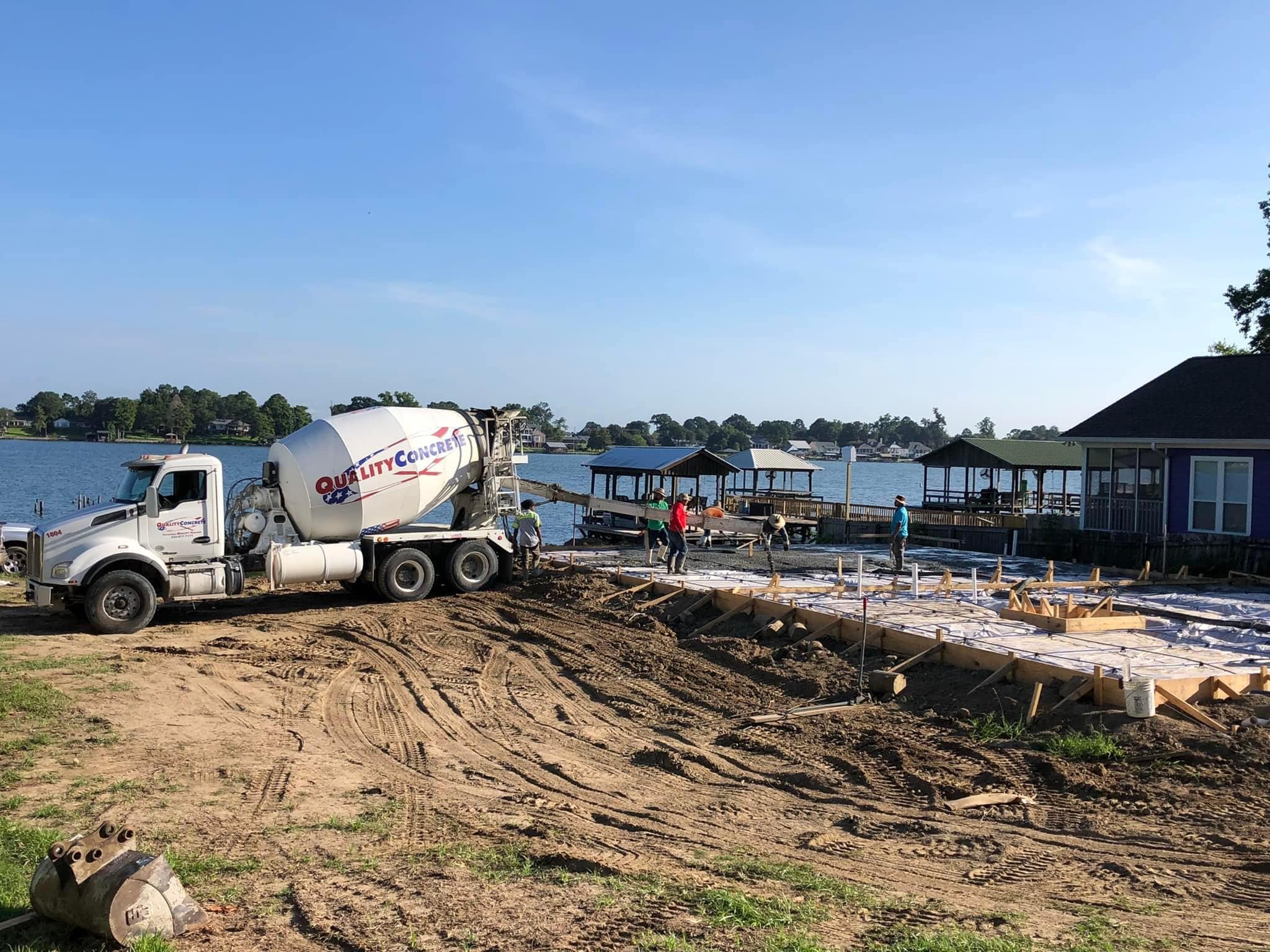 quality concrete truck by the lake and construction workers on a construction site